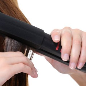 flat iron applying on female brunette hair